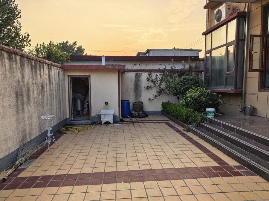 Empty tiled backyard courtyard before hydroponic tower installation